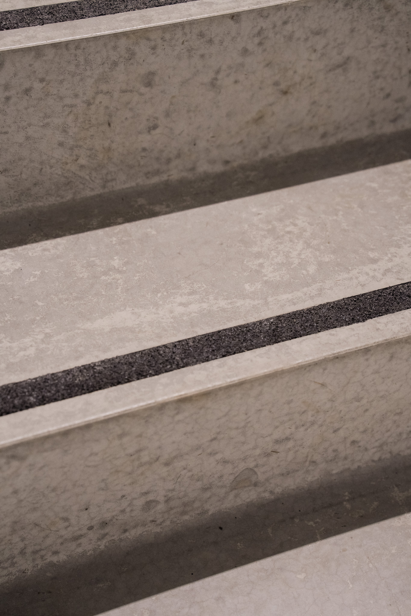 Nærbilde av reparerte betongtrapper med jevn overflate og sklisikre striper på trinnene